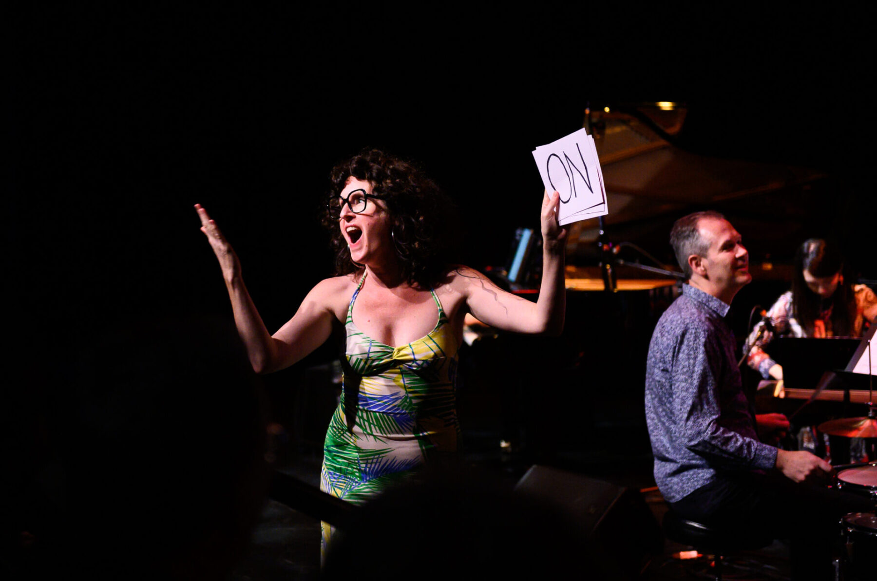 Music on Main's Big Band performing Stay On It with Julia Ulhela holding a sign saying 'on' to get audience to sing.