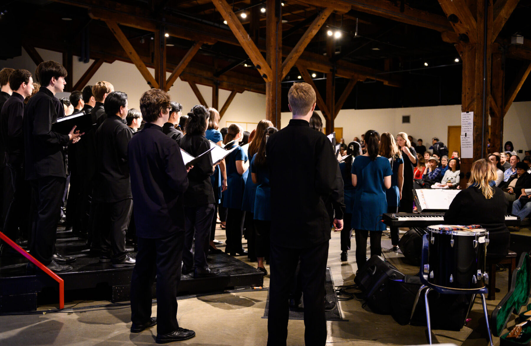 Photo of the backs of Vancouver Youth Choir performing in the Exhibition Hall.